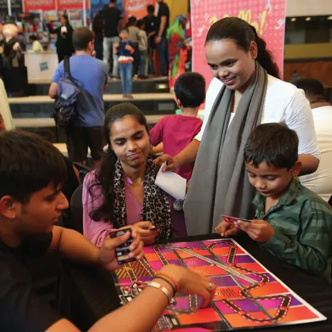 Visitors playing a board game at a convention booth