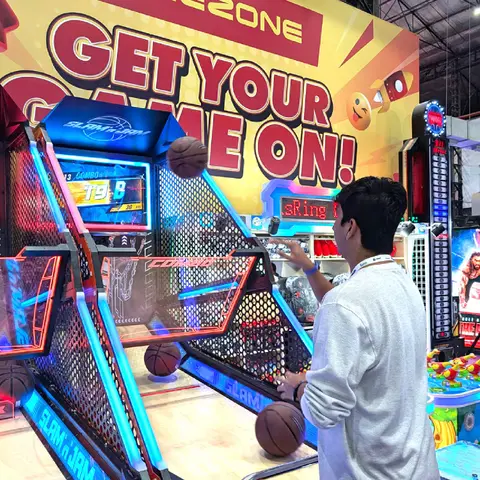 An arcade basketball machine with a 'Get your game on' sign
